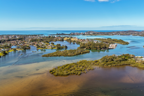 Aerial view capturing the winding river at Tuncurry as it flows around small tree covered islands - Australian Stock Image