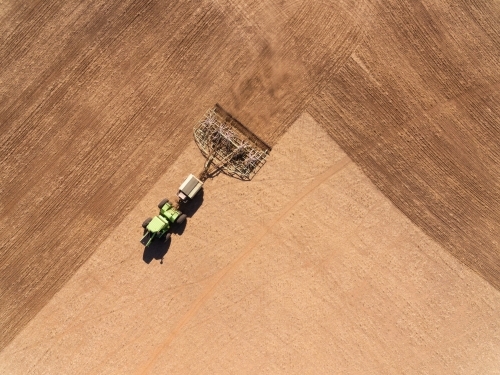 Aerial view looking down on farm machinery sowing crop - Australian Stock Image