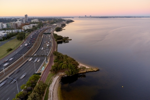 Aerial view looking down the Kwinana Freeway and Swan River at dawn in Perth, Australia.