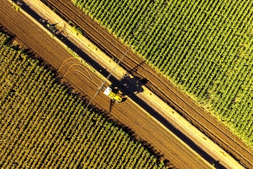 Aerial view of a boom sprayer turning between crops of sorghum
