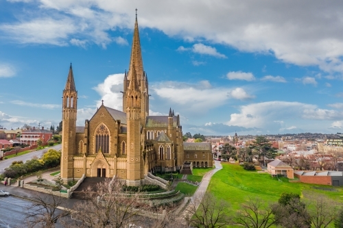 Aerial view of a cathedral on a grassy hillside in a regional city - Australian Stock Image