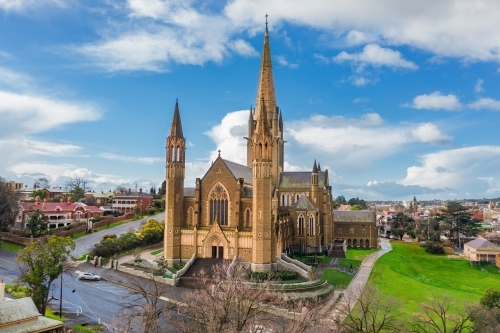 Aerial view of a cathedral on a grassy hillside in a regional city - Australian Stock Image