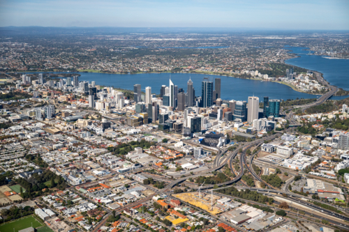 Aerial view of a city CBD and suburbs beside a wide river stretching to the distant horizon - Australian Stock Image