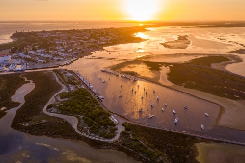 Aerial view of a coastal marina under a golden sunset. - Australian Stock Image