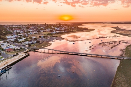 Aerial view of a coastal marina under a golden sunset.