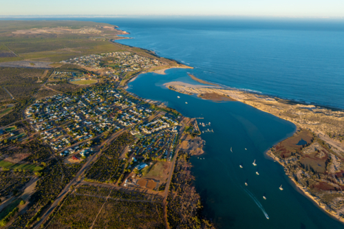 Aerial view of a coastal town, marina and estuary leading into the open ocean. - Australian Stock Image