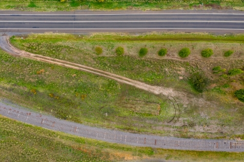 Aerial view of a dirt track off a country road leading to disused railway line - Australian Stock Image