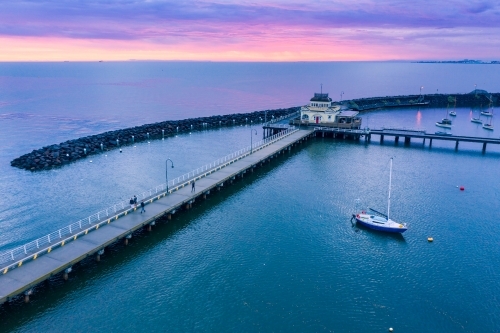 Aerial view of a dramatic purple sunset over a coastal jetty and breakwater - Australian Stock Image
