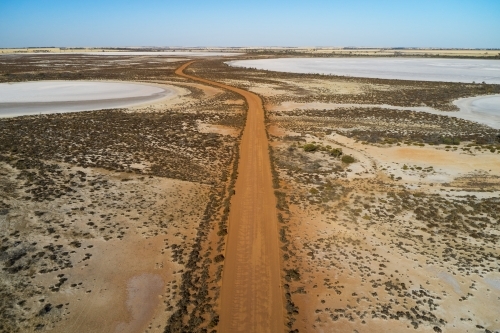 Aerial view of a gravel road going through small dry salt lakes in the Australian summer. - Australian Stock Image