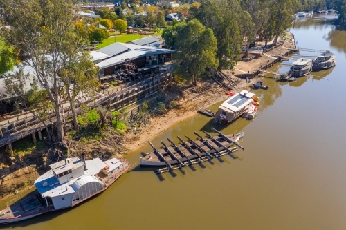 Aerial view of a line of paddle steamers anchored along a river bank
