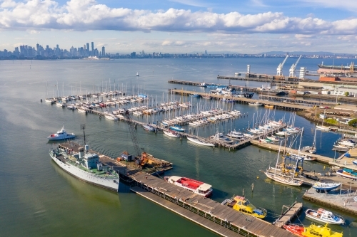 Aerial view of a naval ship at a dock at a bay side harbour - Australian Stock Image