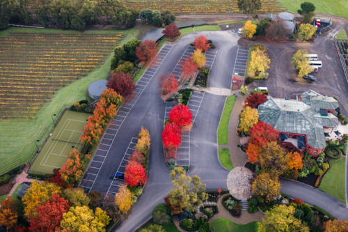 Aerial view of a parking lot and tennis court with autumn foliage - Australian Stock Image