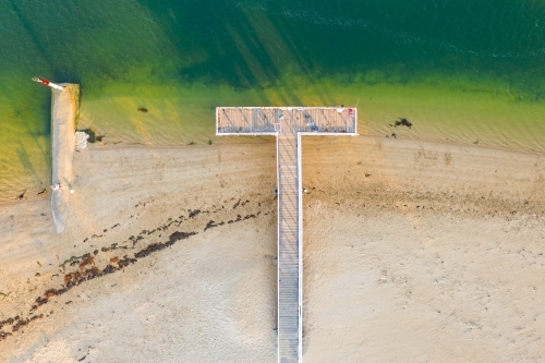 Aerial view of a people fishing on a T shaped jetty at the coast - Australian Stock Image