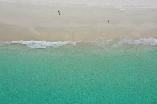 Aerial view of a Perth beach in summer, with the long shadows of people walking in the early morning - Australian Stock Image