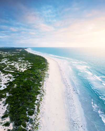 Aerial view of a pristine Australian coastline with turquoise waters and long stretch of white sand - Australian Stock Image