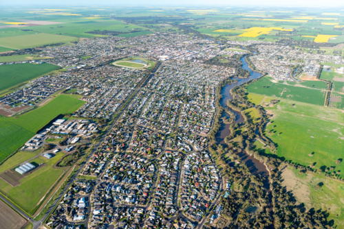 Aerial view of a regional city surrounded by green farmland - Australian Stock Image