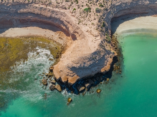 Aerial view of a rocky coast headland protruding into a calm bay with cliffs and beaches alongside - Australian Stock Image