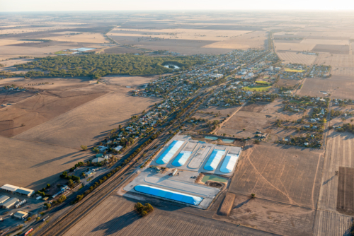 Aerial view of a rural town and grain storage surrounded by farmland. - Australian Stock Image