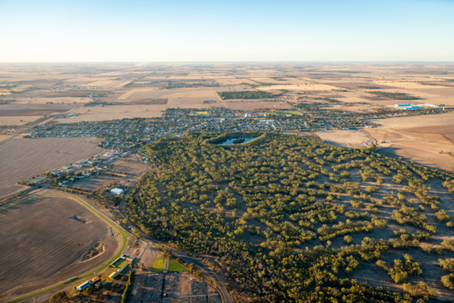 Aerial view of a rural town and surrounding forested reserve and farmland - Australian Stock Image