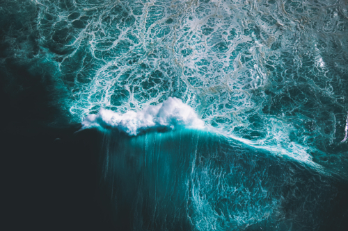 Aerial view of a single ocean wave as it crests and breaks - Australian Stock Image