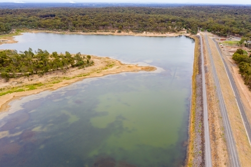 Aerial view of a small island in a reservoir and dam wall - Australian Stock Image