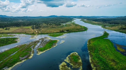 Aerial view of a winding river cutting through a lush, green landscape - Australian Stock Image
