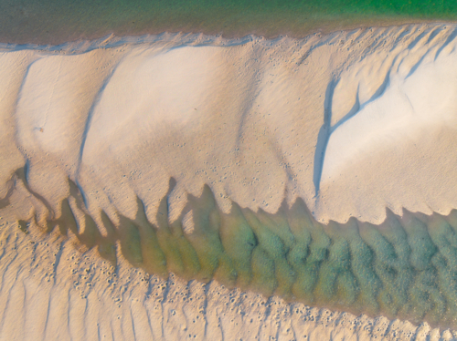 Aerial view of abstract pattern and water flow over sand in a coastal lake system - Australian Stock Image
