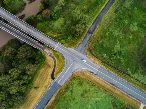 Aerial view of an open rural crossroads bordered by paddocks and hunter river with bridge over it - Australian Stock Image