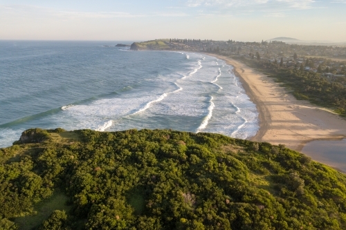 Aerial view of beach and coastal town at sunset - Australian Stock Image