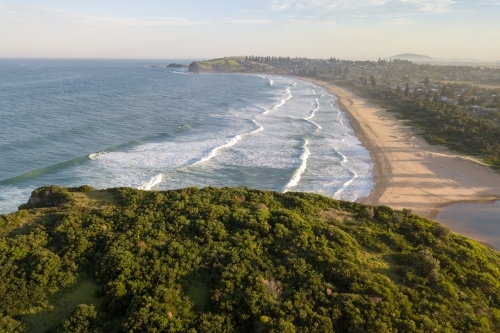 Aerial view of beach and coastal town at sunset