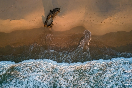 Aerial view of beach and surf at sunrise