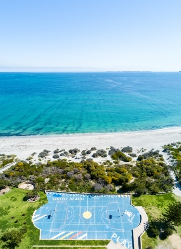 Aerial view of beachside basketball court and ocean.