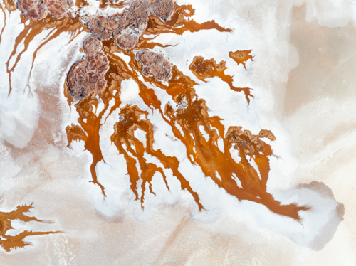 Aerial view of brown groundwater making patterns in a salt lake - Australian Stock Image
