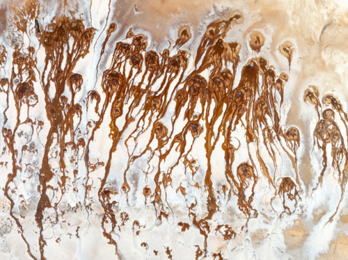 Aerial view of brown groundwater making patterns in a salt lake - Australian Stock Image