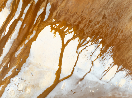 Aerial view of brown groundwater making patterns in a salt lake - Australian Stock Image