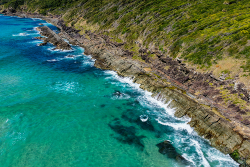 Aerial view of Burgess Beach in Forster, capturing jagged rocky coastline - Australian Stock Image