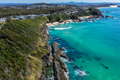 Aerial view of Burgess Beach in Forster, capturing jagged rocky coastline - Australian Stock Image