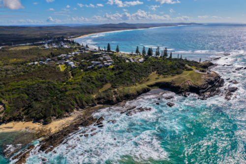 Aerial view of clear turquoise ocean water and rugged rocky coastline at Brooms Head - Australian Stock Image