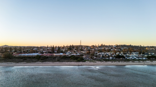 Aerial view of coastal town and caravan park at sunset - Australian Stock Image