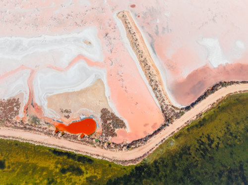 Aerial view of colourful salt evaporation ponds and levee banks at a coastal salt farm - Australian Stock Image