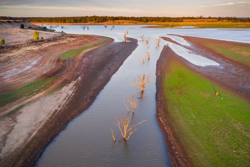 Aerial view of creeks and rivers flowing into a drying reservoir. - Australian Stock Image