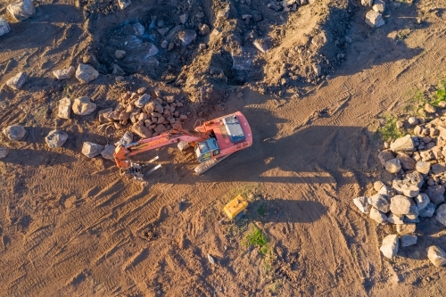 Aerial view of earth moving machinery shifting boulders in a paddock - Australian Stock Image