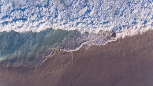 Aerial view of foaming waves  on the seashore - Australian Stock Image