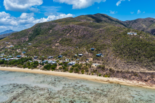 Aerial view of Hydeaway Bay showcasing its vibrant turquoise water, rocky headlands - Australian Stock Image