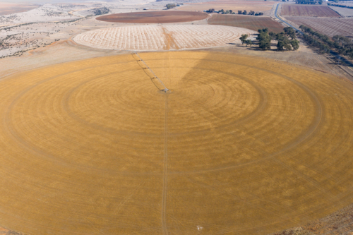 Aerial view of irrigation sprinkler on a dry circular field - Australian Stock Image