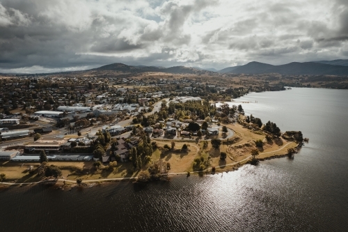Aerial view of Jindabyne main town centre with the Snowy Mountains in the background - Australian Stock Image