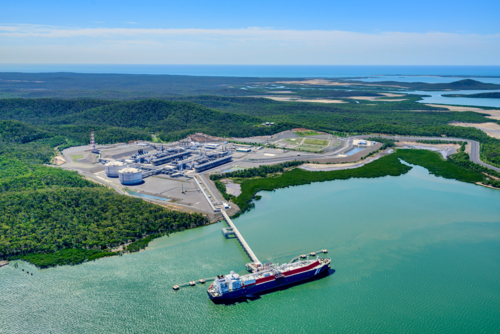 Aerial view of liquified natural gas plant and LNG ship docked at a long pier - Australian Stock Image