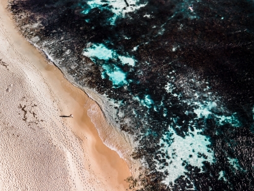 Aerial view of lone person walking along sand on North Beach, WA