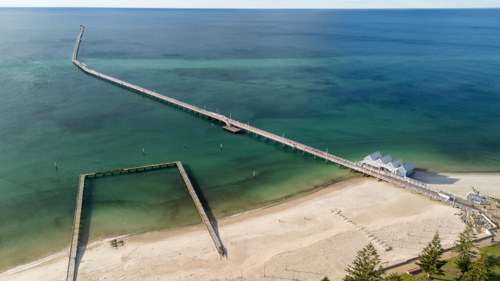 Aerial view of long wooden jetty on the coast - Australian Stock Image