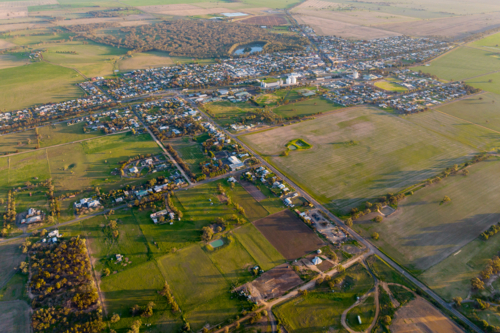 Aerial view of Nhill township surrounded by farmland at sunset - Australian Stock Image